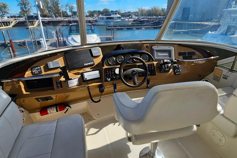 Slide: The Image of 2004 Carver 444 Cockpit Motor Yacht helm with navigation equipment and comfortable seating. - 15
