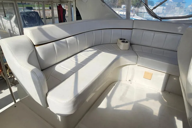 Slide: The Image of 2004 Carver 444 Cockpit Motor Yacht interior with white leather seating and cup holder. - 23