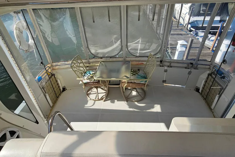 Slide: The Image of 2004 Carver 444 Cockpit Motor Yacht interior with table and chairs on deck. - 26