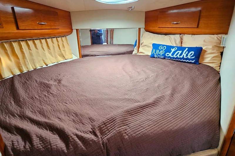 Slide: The Image of Cozy bedroom in 2004 Carver 444 Cockpit Motor Yacht with brown bedding and decorative pillow. - 40
