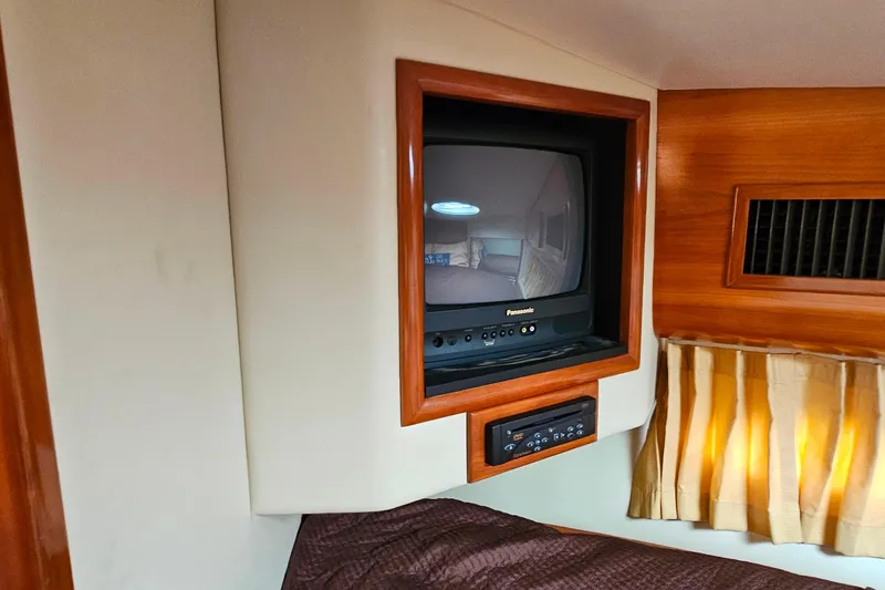 Slide: The Image of 2004 Carver 444 Cockpit Motor Yacht interior with vintage Panasonic TV and wood paneling. - 41
