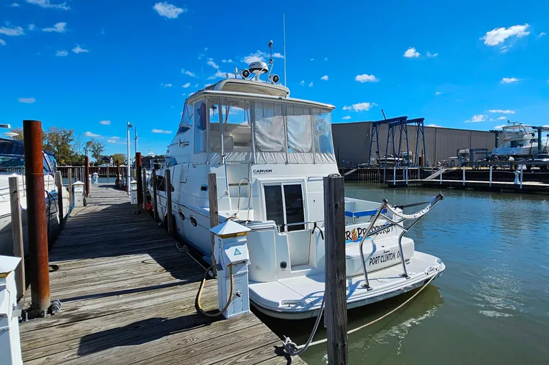 Slide: The Image of 2004 Carver 444 Cockpit Motor Yacht docked at marina under clear blue sky. - 52