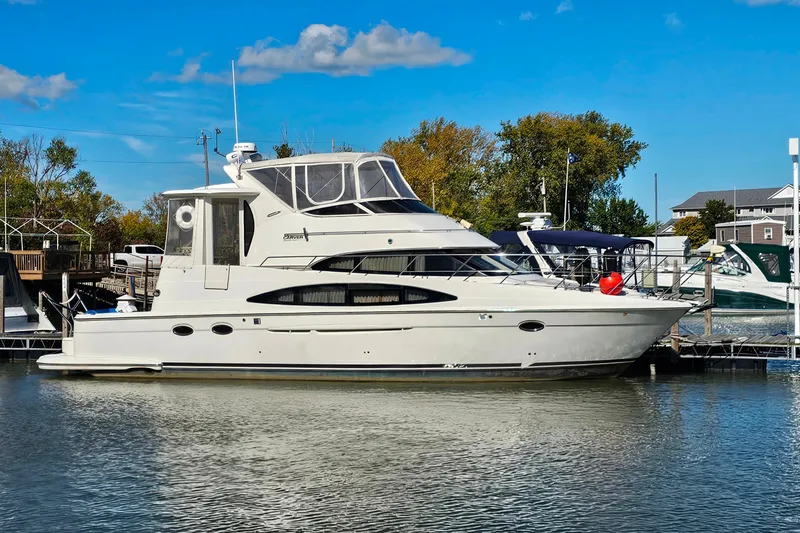 Slide: The Image of 2004 Carver 444 Cockpit Motor Yacht docked in a marina under clear blue skies. - 55
