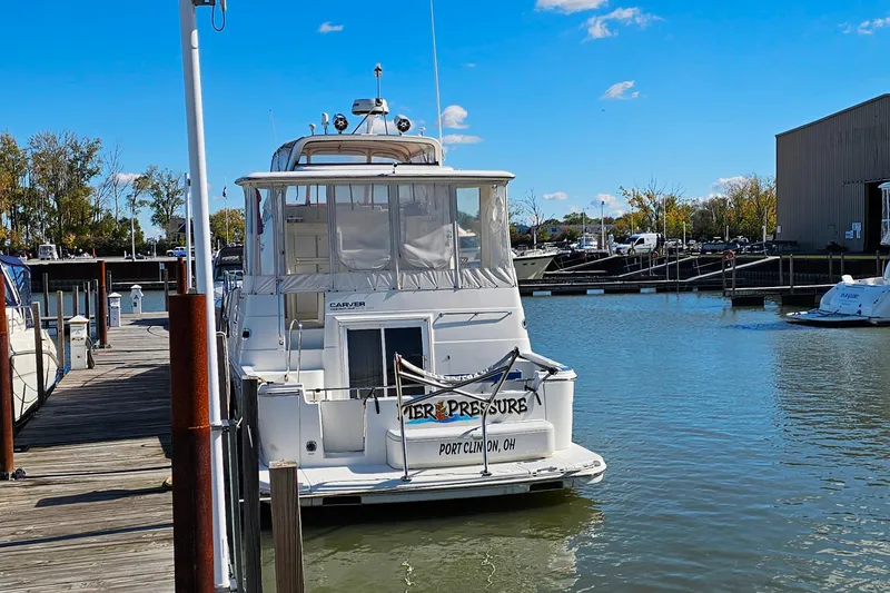 Slide: The Image of 2004 Carver 444 Cockpit Motor Yacht docked at marina under clear blue sky. - 6