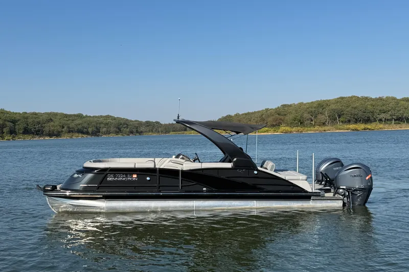 The Image of 2023 Bennington QX 27 QXSBAX2 pontoon boat on a serene lake. - 1