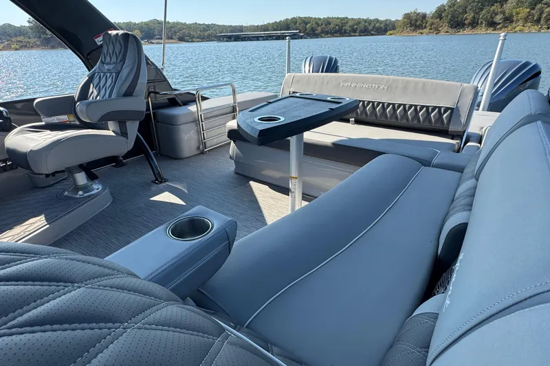 Slide: The Image of 2023 Bennington QX 27 QXSBAX2 luxury boat interior with plush seating and scenic lake view. - 16