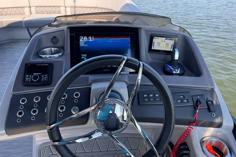 Slide: The Image of 2023 Bennington QX 27 QXSBAX2 boat dashboard with steering wheel and navigation displays. - 20