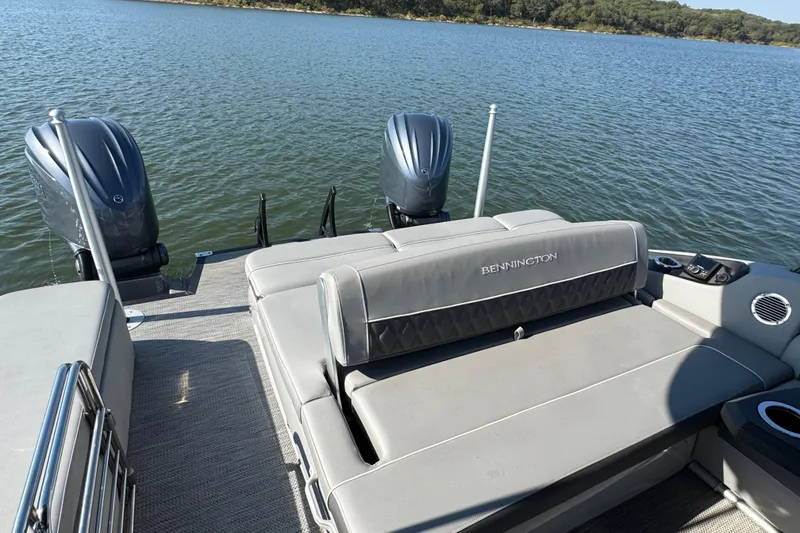 Slide: The Image of 2023 Bennington QX 27 QXSBAX2 pontoon boat with dual engines on a serene lake. - 24