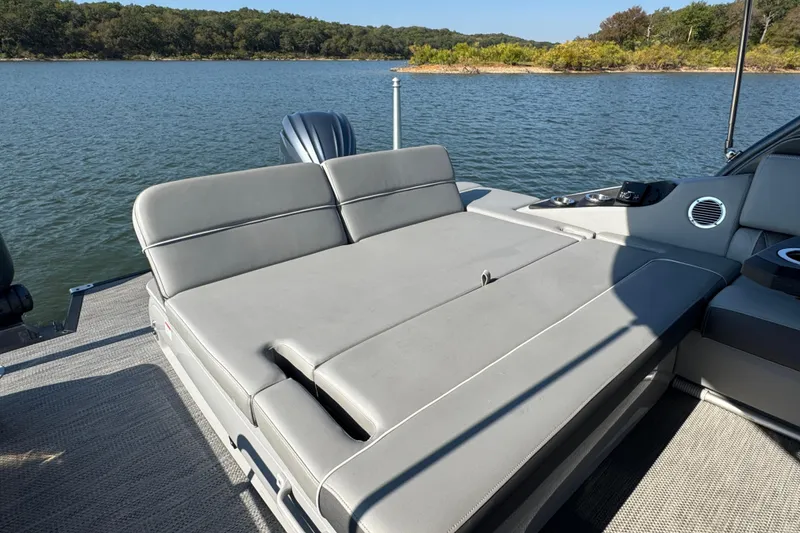 Slide: The Image of 2023 Bennington QX 27 QXSBAX2 pontoon boat with luxurious seating on a serene lake. - 27