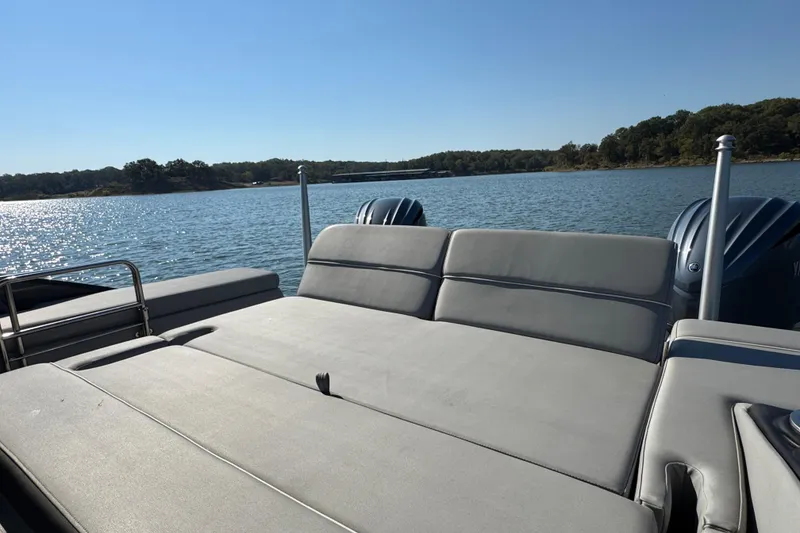 Slide: The Image of 2023 Bennington QX 27 QXSBAX2 pontoon boat on a serene lake. - 28