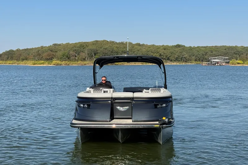Slide: The Image of 2023 Bennington QX 27 QXSBAX2 pontoon boat on a serene lake. - 4