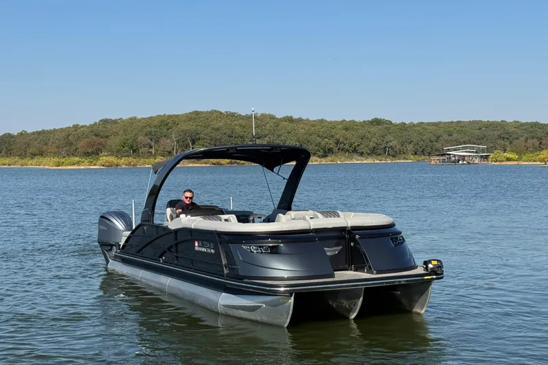 Slide: The Image of 2023 Bennington QX 27 QXSBAX2 pontoon boat on a serene lake. - 5