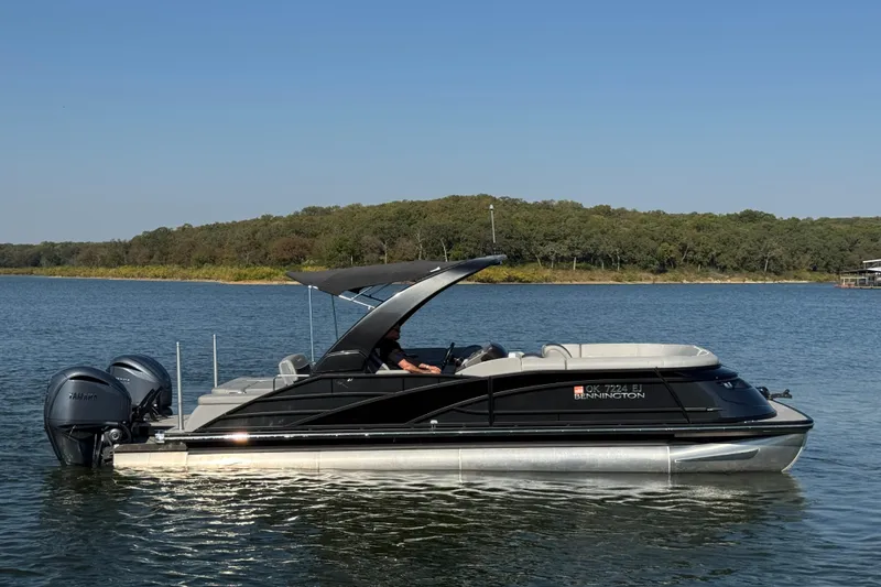 Slide: The Image of 2023 Bennington QX 27 QXSBAX2 pontoon boat on a serene lake. - 7