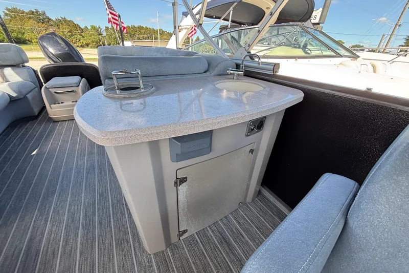 Slide: The Image of 2021 Premier 270 Intrigue RF boat interior with countertop and sink, featuring comfortable seating. - 22