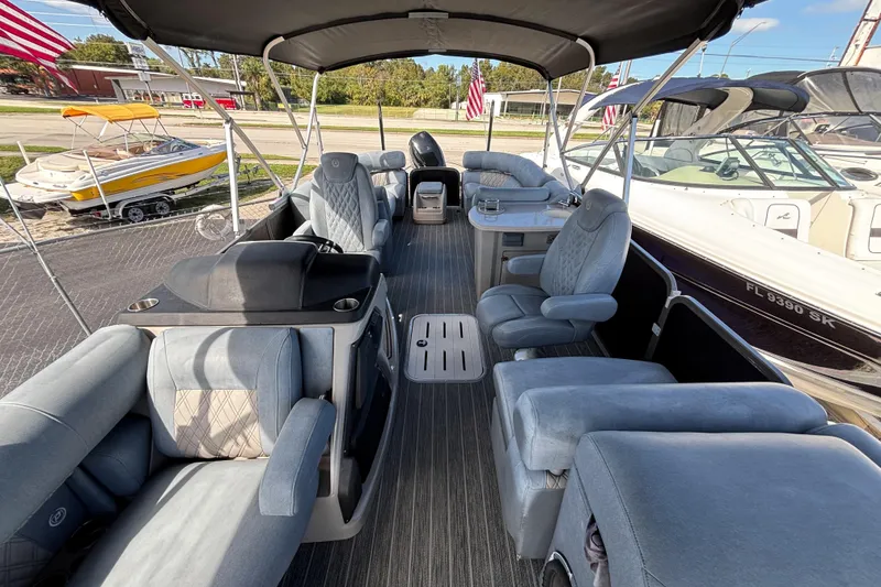 Slide: The Image of 2021 Premier 270 Intrigue RF pontoon boat interior with plush seating and canopy. - 5