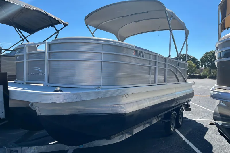The Image of 2021 Bennington 22SRX pontoon boat with canopy on trailer in parking lot. - 0