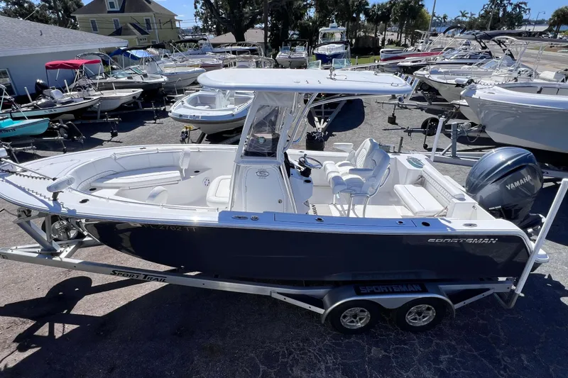 Slide: The Image of 2023 Sportsman Open 242 Center Console boat on trailer, surrounded by other boats. - 10