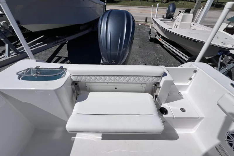 Slide: The Image of 2023 Sportsman Open 242 Center Console boat with cushioned seating and motor. - 14