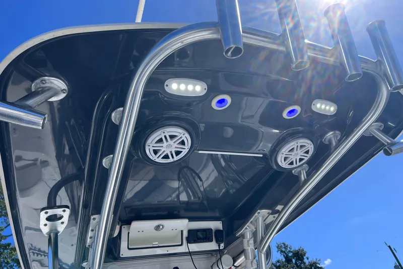 Slide: The Image of 2023 Sportsman Open 242 Center Console boat with speakers and rod holders under blue sky. - 27