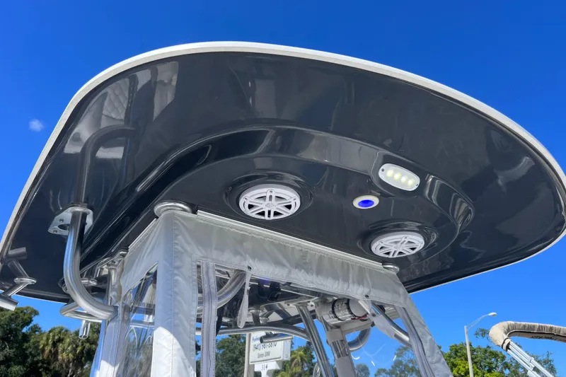 Slide: The Image of 2023 Sportsman Open 242 Center Console T-top with speakers and lights against blue sky. - 28