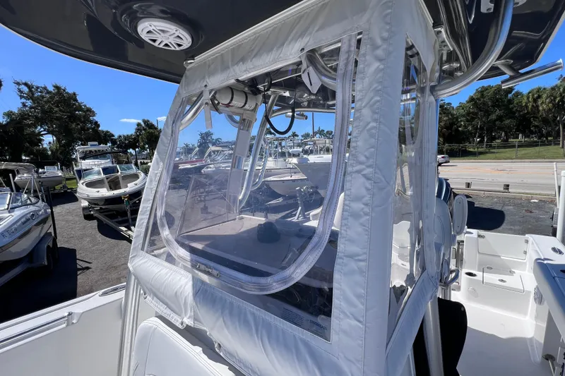 Slide: The Image of 2023 Sportsman Open 242 Center Console boat with protective enclosure, parked outdoors. - 39