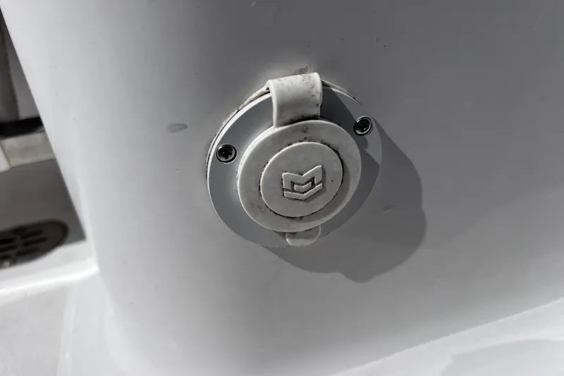 Slide: The Image of 2023 Sportsman Open 242 Center Console boat detail with logo on white surface. - 42