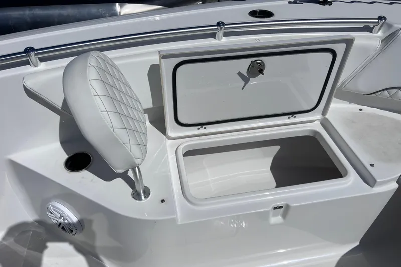 Slide: The Image of 2023 Sportsman Open 242 Center Console boat with open storage compartment and cushioned seat. - 50