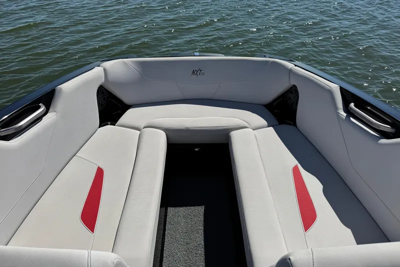 Slide: The Image of 2021 MasterCraft NXT24 boat interior with white and red seating on water. - 10