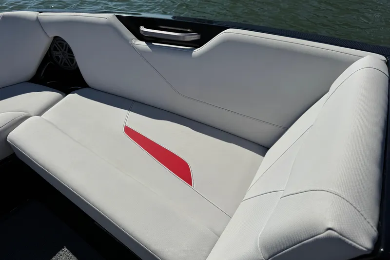 Slide: The Image of 2021 MasterCraft NXT24 boat interior with white and red seating, near water. - 12