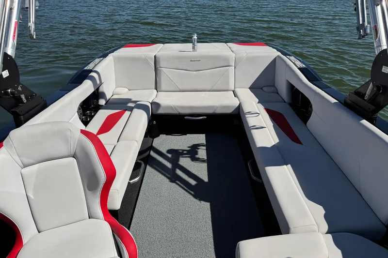 Slide: The Image of 2021 MasterCraft NXT24 boat interior with gray and red seating on the water. - 13