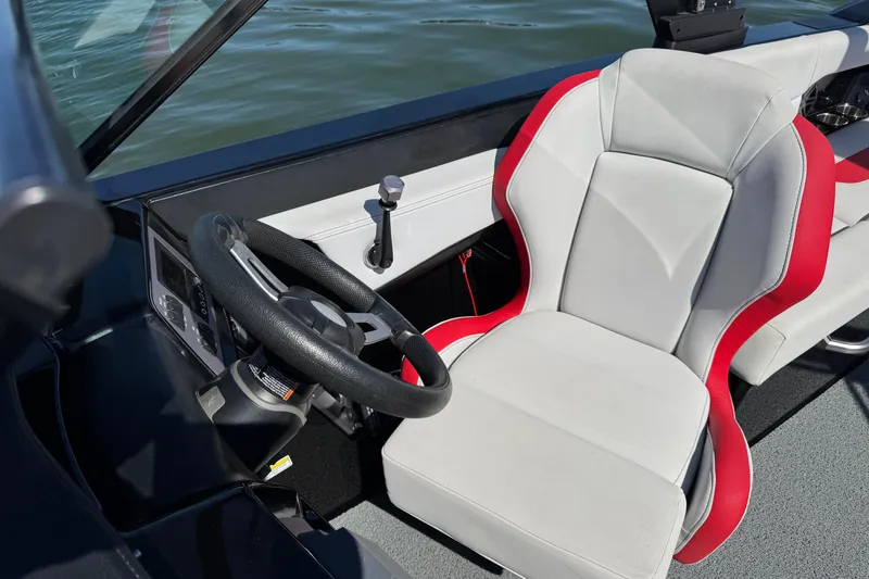 Slide: The Image of 2021 MasterCraft NXT24 boat cockpit with steering wheel and red-trimmed seat. - 14