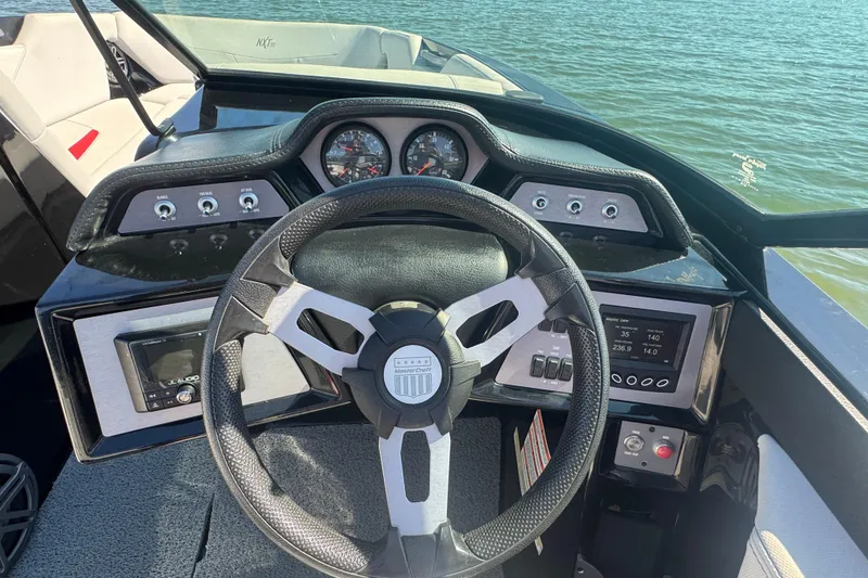 Slide: The Image of Steering wheel and dashboard of 2021 MasterCraft NXT24 boat on water. - 16