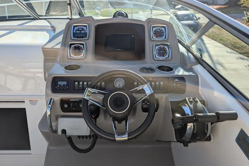 Slide: The Image of 2016 Chaparral 290 Signature boat dashboard with steering wheel and control panel. - 15