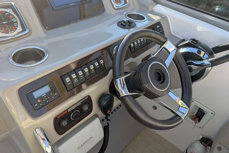 Slide: The Image of 2016 Chaparral 290 Signature boat dashboard with steering wheel and Garmin navigation system. - 17