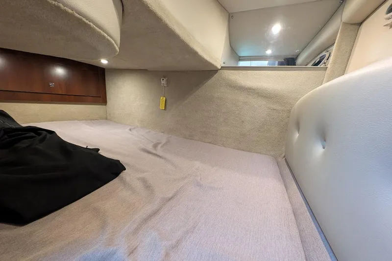Slide: The Image of Interior cabin of 2016 Chaparral 290 Signature boat, featuring cozy bedding and ambient lighting. - 29
