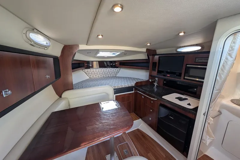 Slide: The Image of Interior of 2016 Chaparral 290 Signature boat with wood accents and modern amenities. - 30