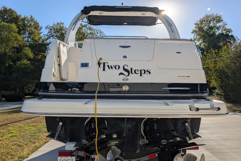 Slide: The Image of 2016 Chaparral 290 Signature boat, rear view, with "Two Steps" name, parked outdoors. - 6