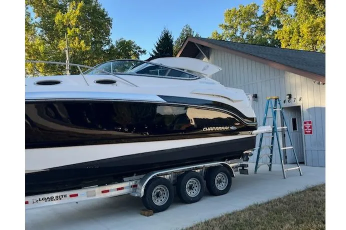 Slide: The Image of 2016 Chaparral 290 Signature boat on trailer near a house with trees in background. - 8