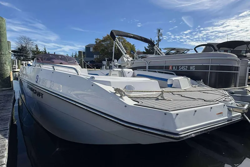 The Image of 2022 Starcraft Crossover 211 SCX OB boat docked at marina under clear sky. - 1