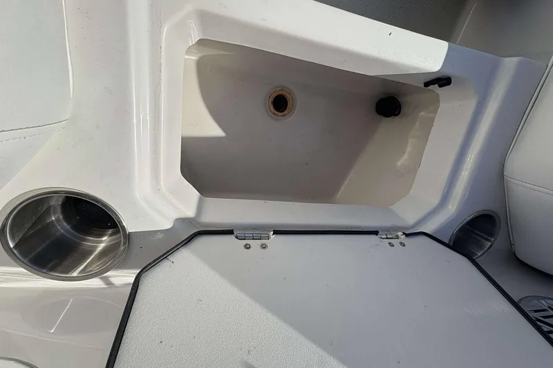 Slide: The Image of 2022 Starcraft Crossover 211 SCX OB boat storage compartment with cup holders. - 16