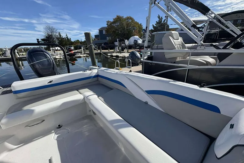 Slide: The Image of 2022 Starcraft Crossover 211 SCX OB boat interior with seating, docked at marina. - 21