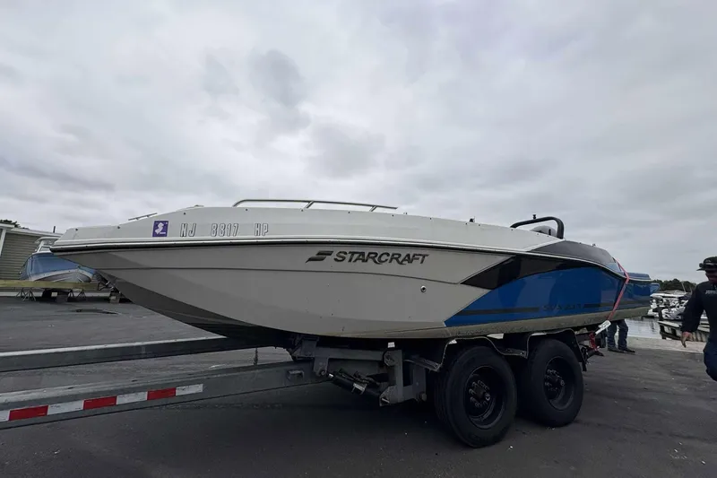 Slide: The Image of 2022 Starcraft Crossover 211 SCX OB boat on trailer, overcast sky background. - 6