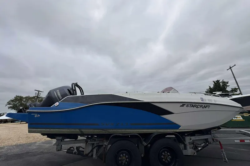 Slide: The Image of 2022 Starcraft Crossover 211 SCX OB boat on trailer, overcast sky background. - 7