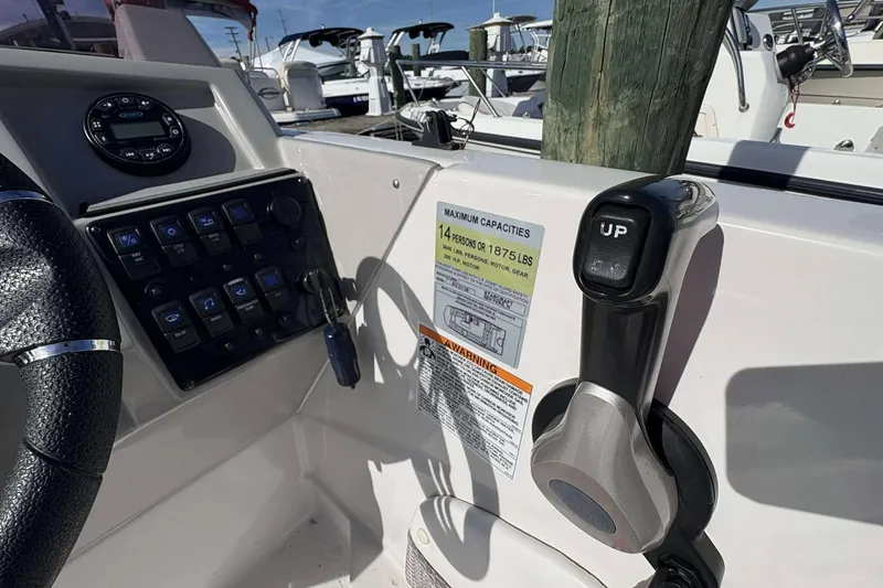 Slide: The Image of 2022 Starcraft Crossover 211 SCX OB boat dashboard with controls and capacity label. - 8