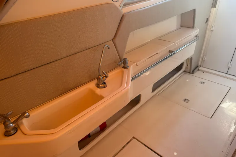 Slide: The Image of Interior of 1995 Sea Ray 500 Sundancer yacht, featuring a compact sink and storage area. - 18