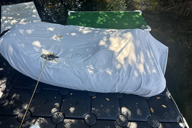 Slide: The Image of Covered 1995 Sea Ray 500 Sundancer boat on floating dock, surrounded by water and foliage. - 22