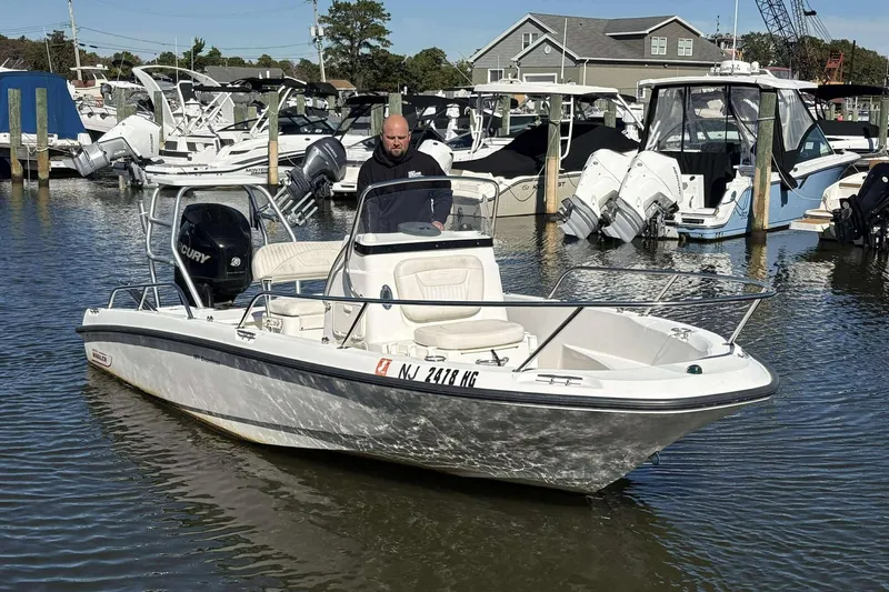 The Image of 2011 Boston Whaler 180 Dauntless boat docked in marina with multiple vessels. - 1