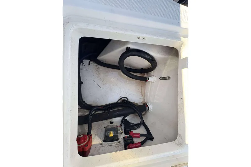 Slide: The Image of 2011 Boston Whaler 180 Dauntless storage compartment with wiring and hoses visible. - 16