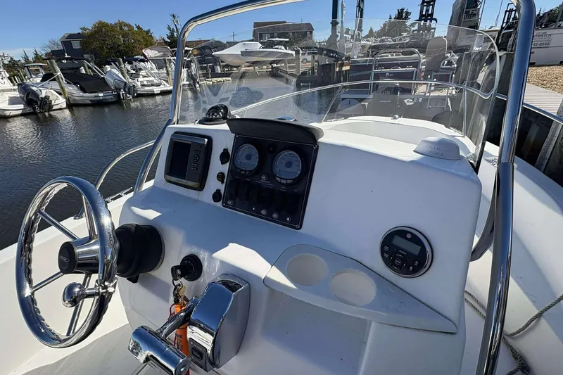 Slide: The Image of 2011 Boston Whaler 180 Dauntless boat console with steering wheel and gauges at marina. - 8