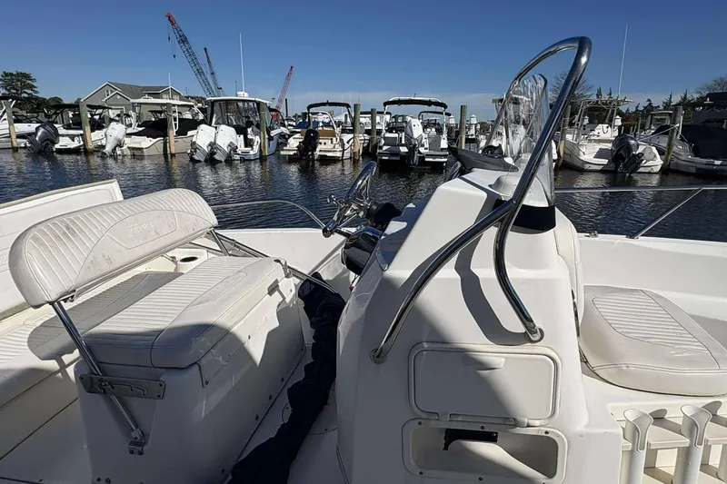 Slide: The Image of 2011 Boston Whaler 180 Dauntless boat interior at marina, featuring seating and console. - 9